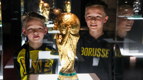 Zwei Jungen schauen sich den WM-Pokal an